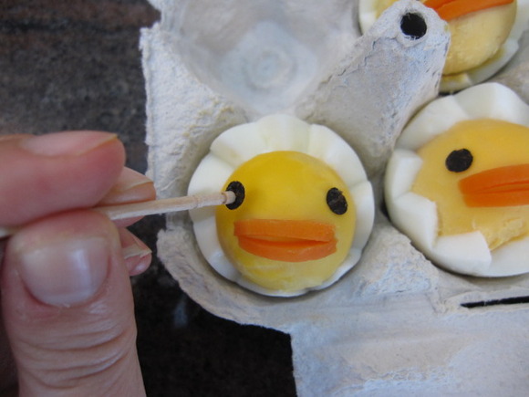 Receta fácil para niños: colocamos los ojos y el pico sobre las yemas